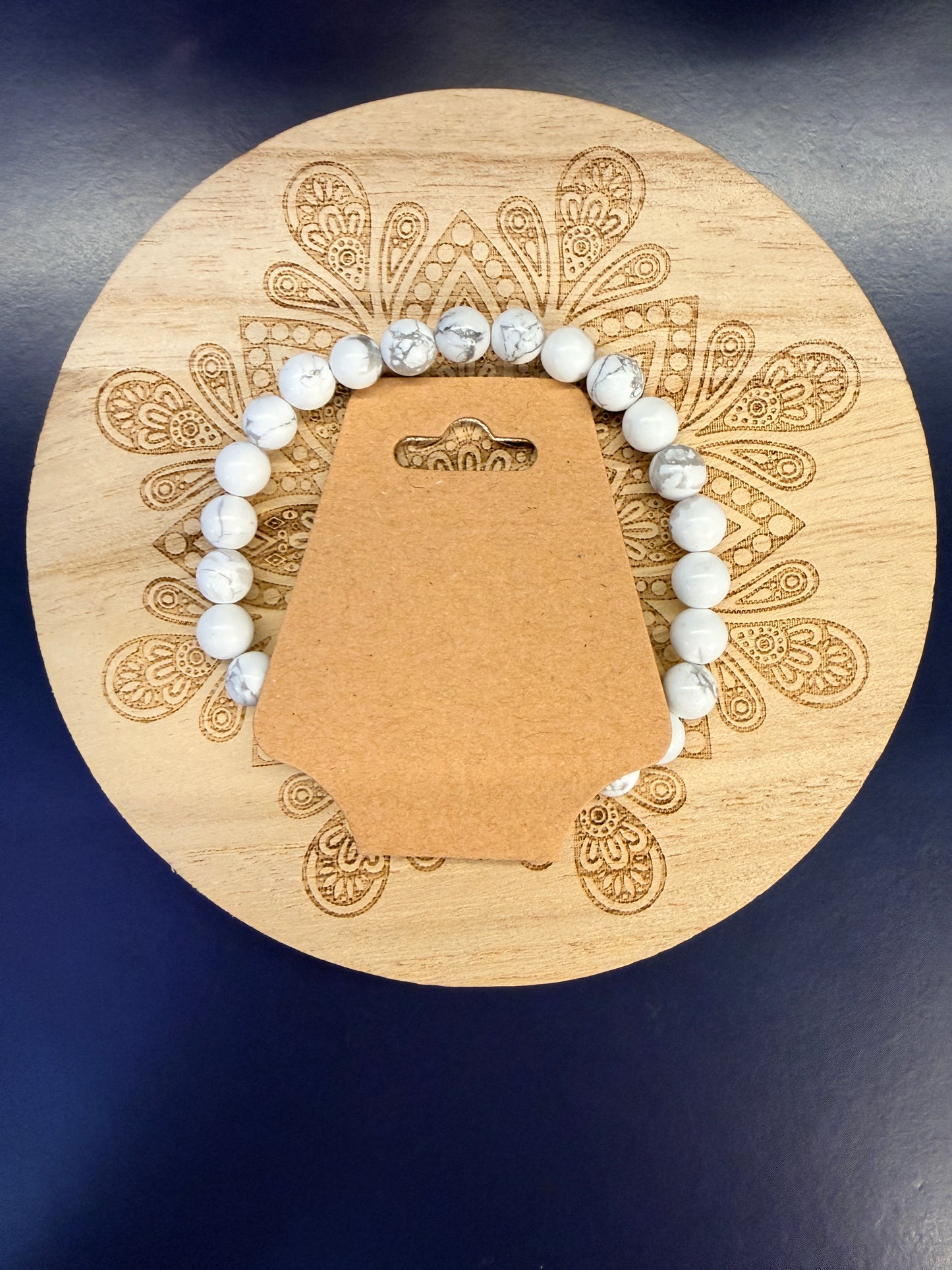 White beaded crystal bracelet on a decorative wooden coaster