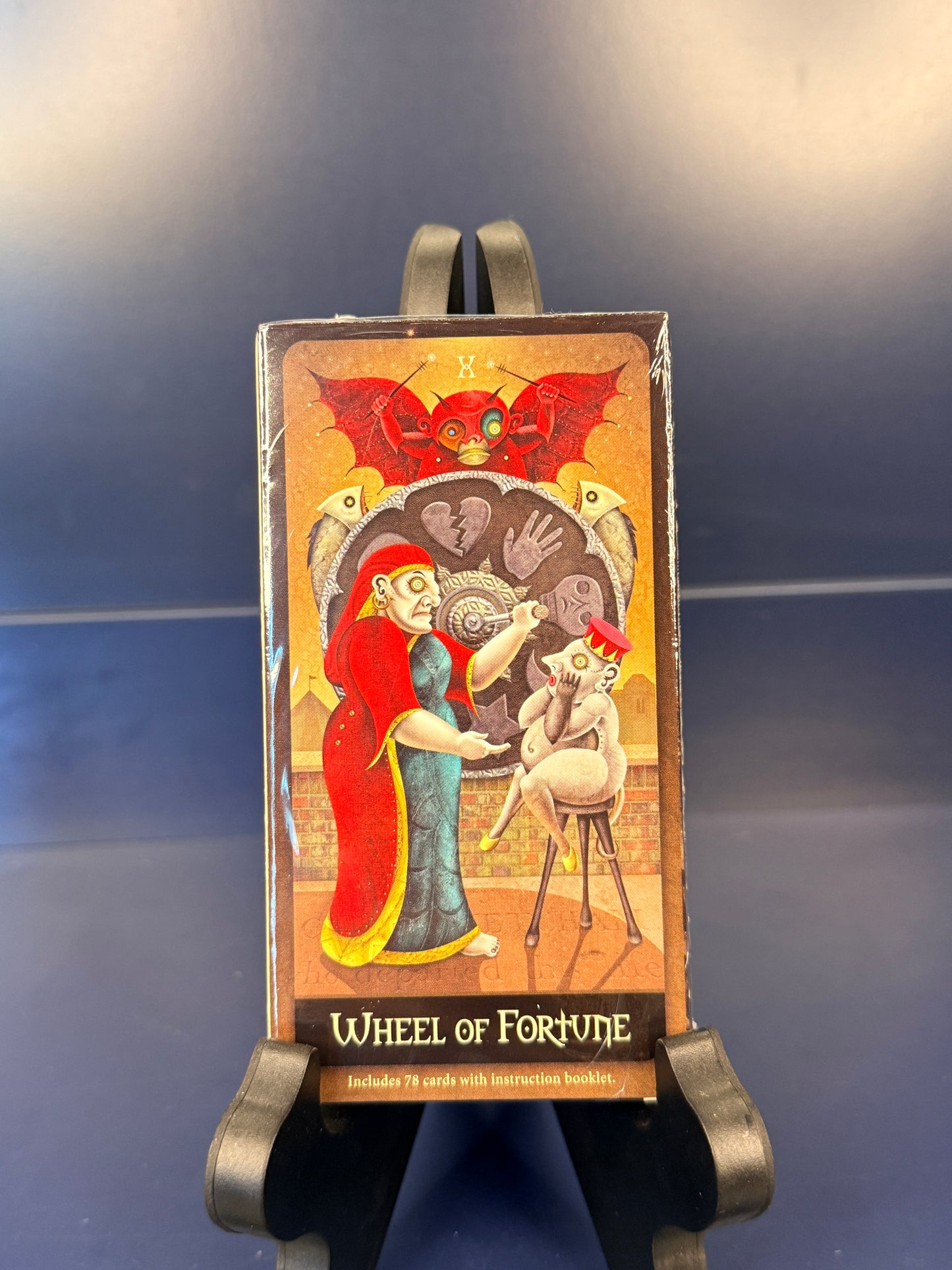 Card from the Deviant Moon Tarot titled 'Wheel of Fortune' on a stand against a dark background