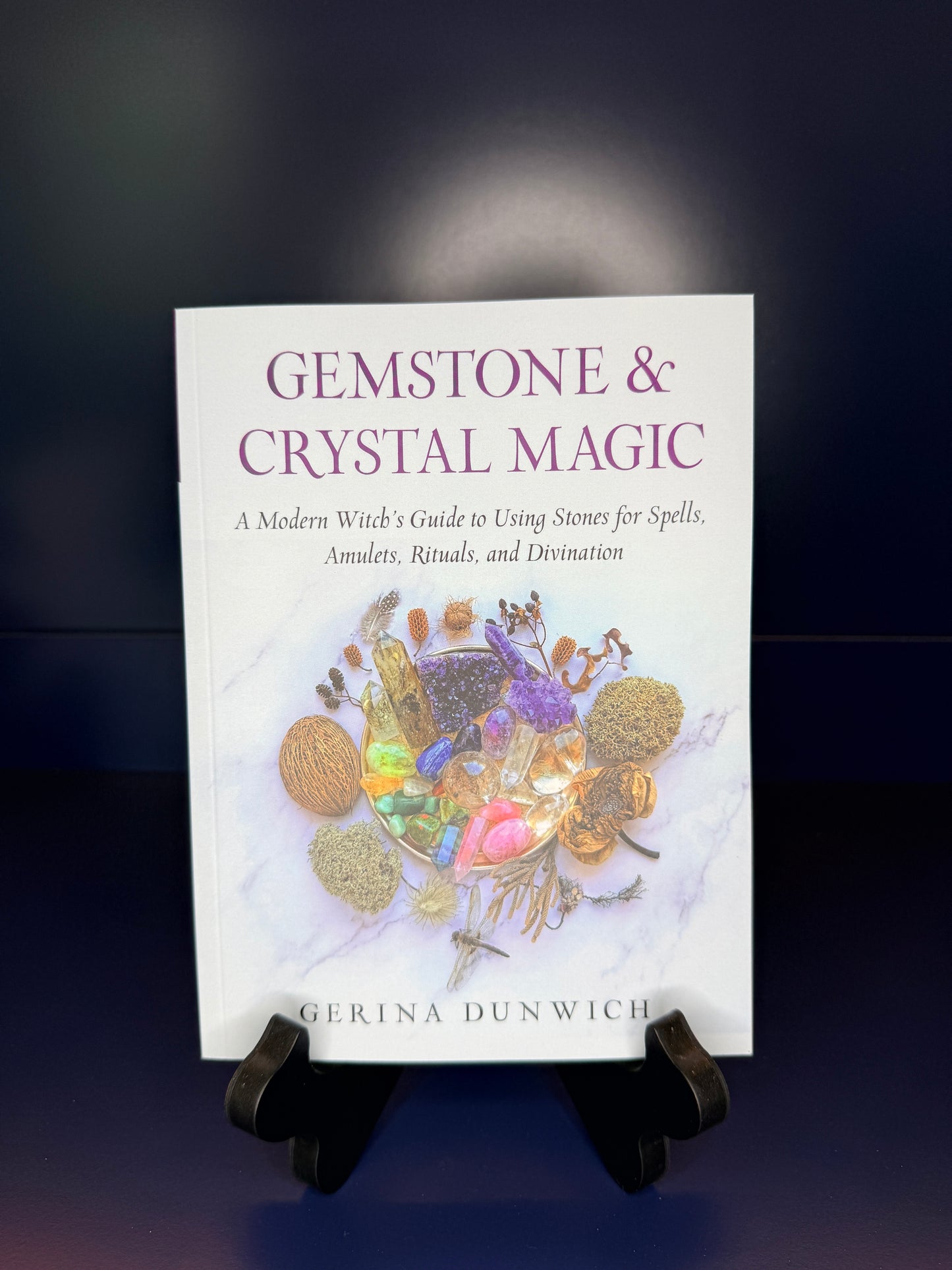 Book titled 'Gemstone & Crystal Magic' by Gherina Dunwich on a dark background