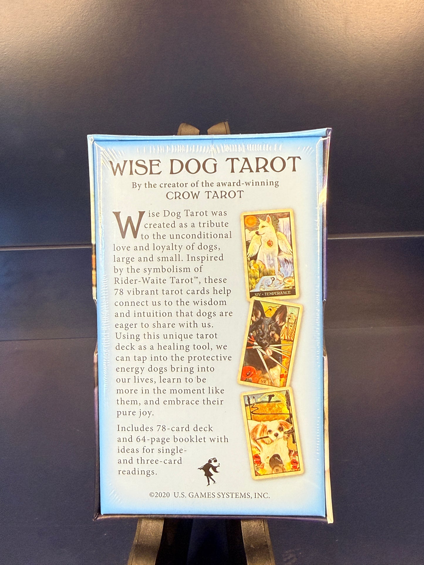 Back of Wise Dog Tarot on a black stand against a blue background