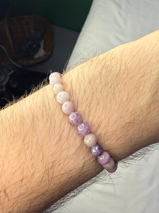 Close-up of a wrist wearing a bracelet with pink and white beads.