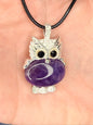 Hand holding an amethyst owl pendant attached to a nylon chain
