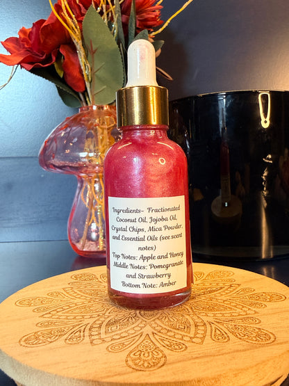 Pink bottle with gold cap on a decorative wooden coaster next to flowers