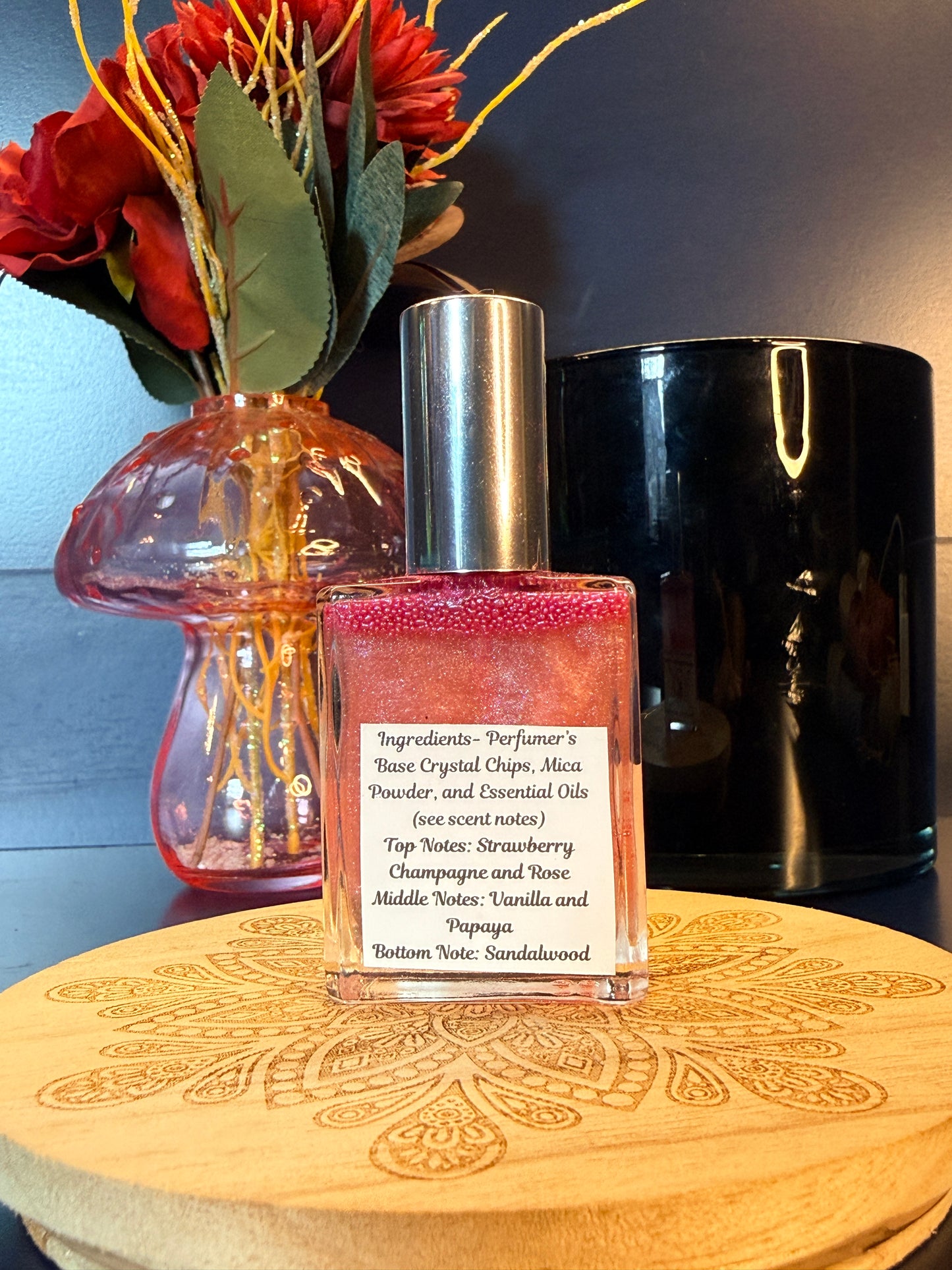 Perfume bottle with a label on a wooden surface with flowers and a dark background