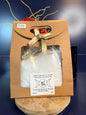 White epsom salt in a brown paper container with a bow, on a wooden coaster