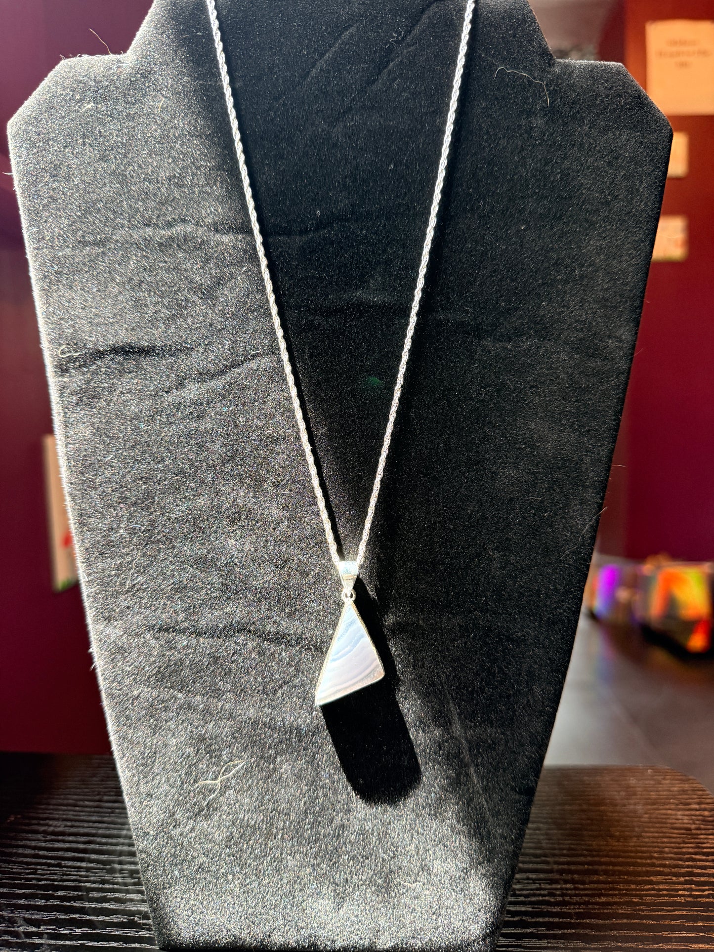 Sterling Silver Necklace resting on a black velvet jewelry stand holding a blue lace agate pendant