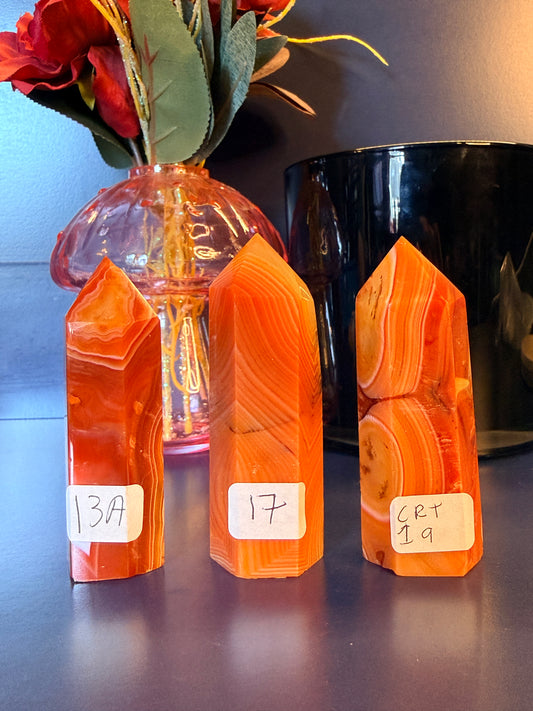 Three orange and red crystal towers in front of a glass mushroom and black jar