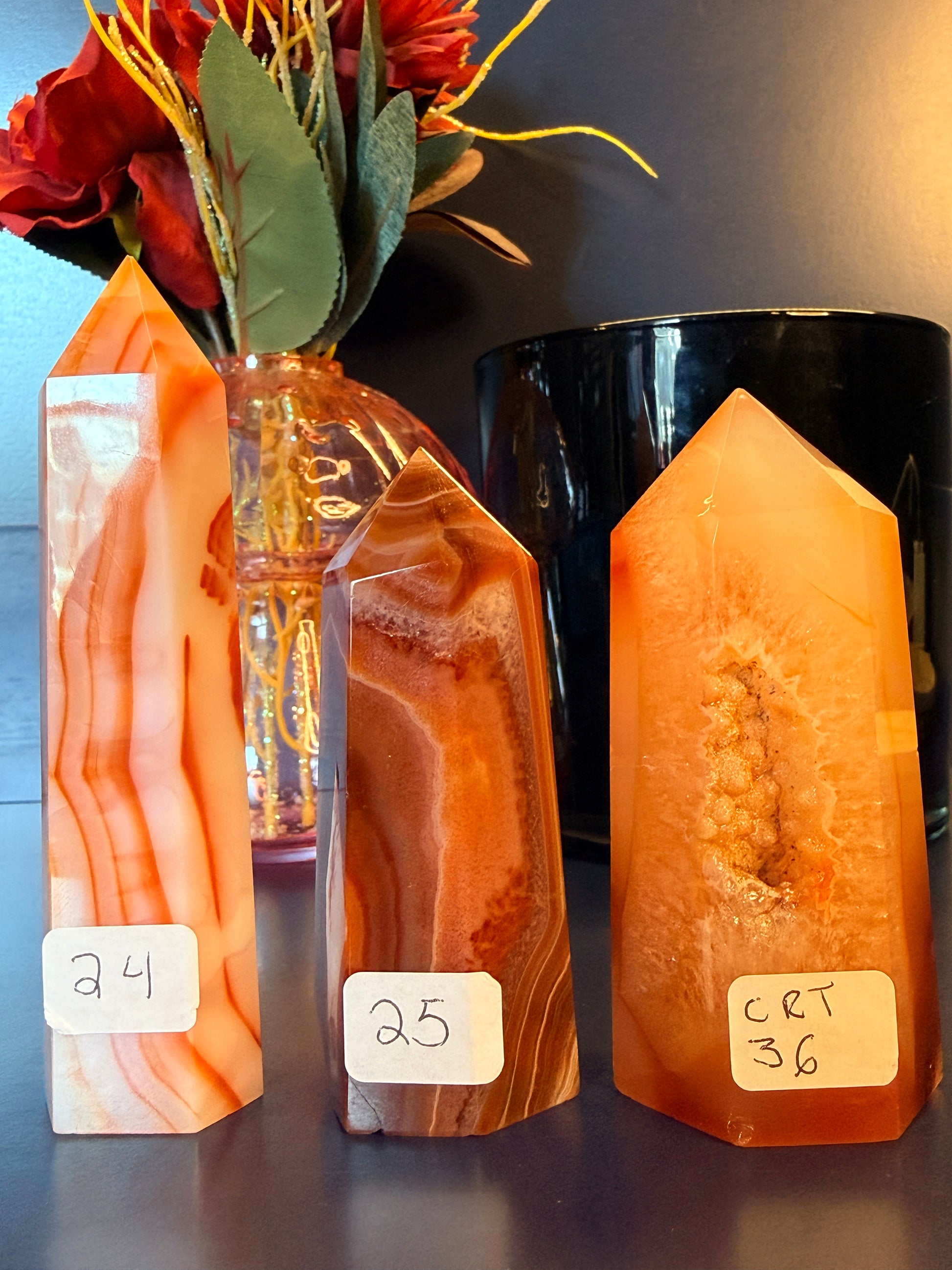 Three orange and red crystal towers in front of a glass mushroom and black jar