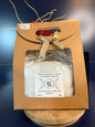 White epsom salt in a brown paper container with a bow, on a wooden coaster
