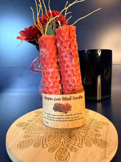 Two red candles in a decorative holder with a decorative wooden coaster and floral arrangement.