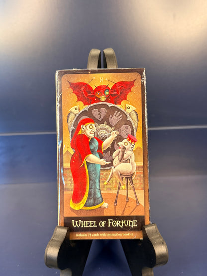 Card from the Deviant Moon Tarot titled 'Wheel of Fortune' on a stand against a dark background