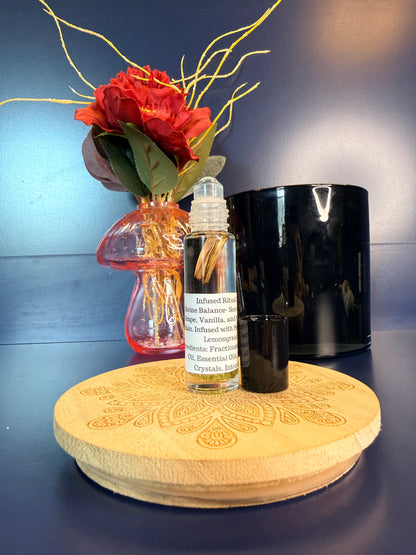 Body Oil Vial sitting on a decorative wooden coaster in front of a red flower and black jar