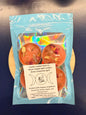 A pack of four orange tealights sitting against a blue background