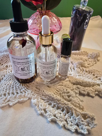 Three glass bottles with clear body oil on a white crochet mat and white sheet