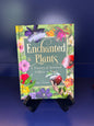 Book titled 'Enchanted Plants' on a stand against a dark background