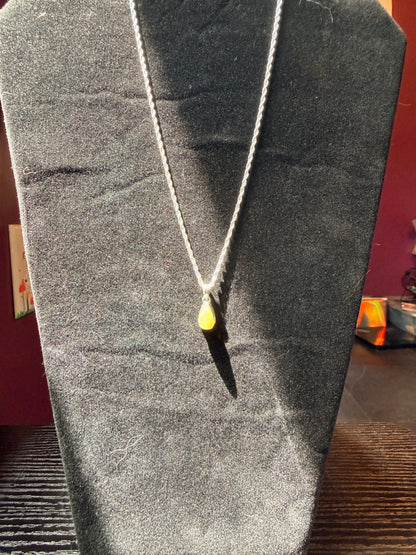 Sterling silver chain on a black velvet jewelry stand holding a teardrop opal pendant