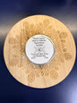 Wooden coaster with intricate patterns and a round metal lip balm on a dark blue background