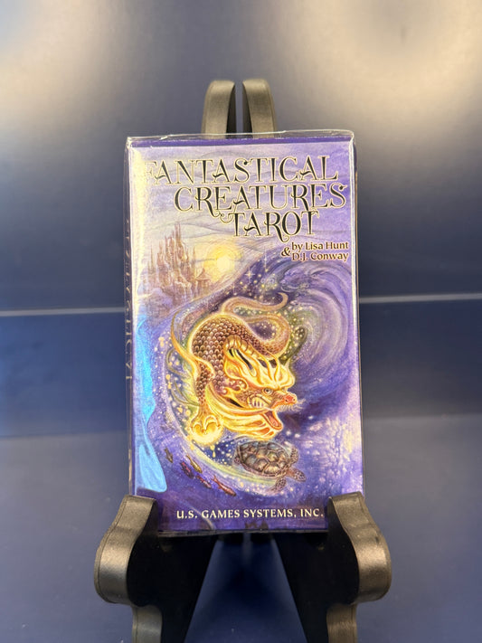Fantastical Creatures Tarot on a black stand against a blue background