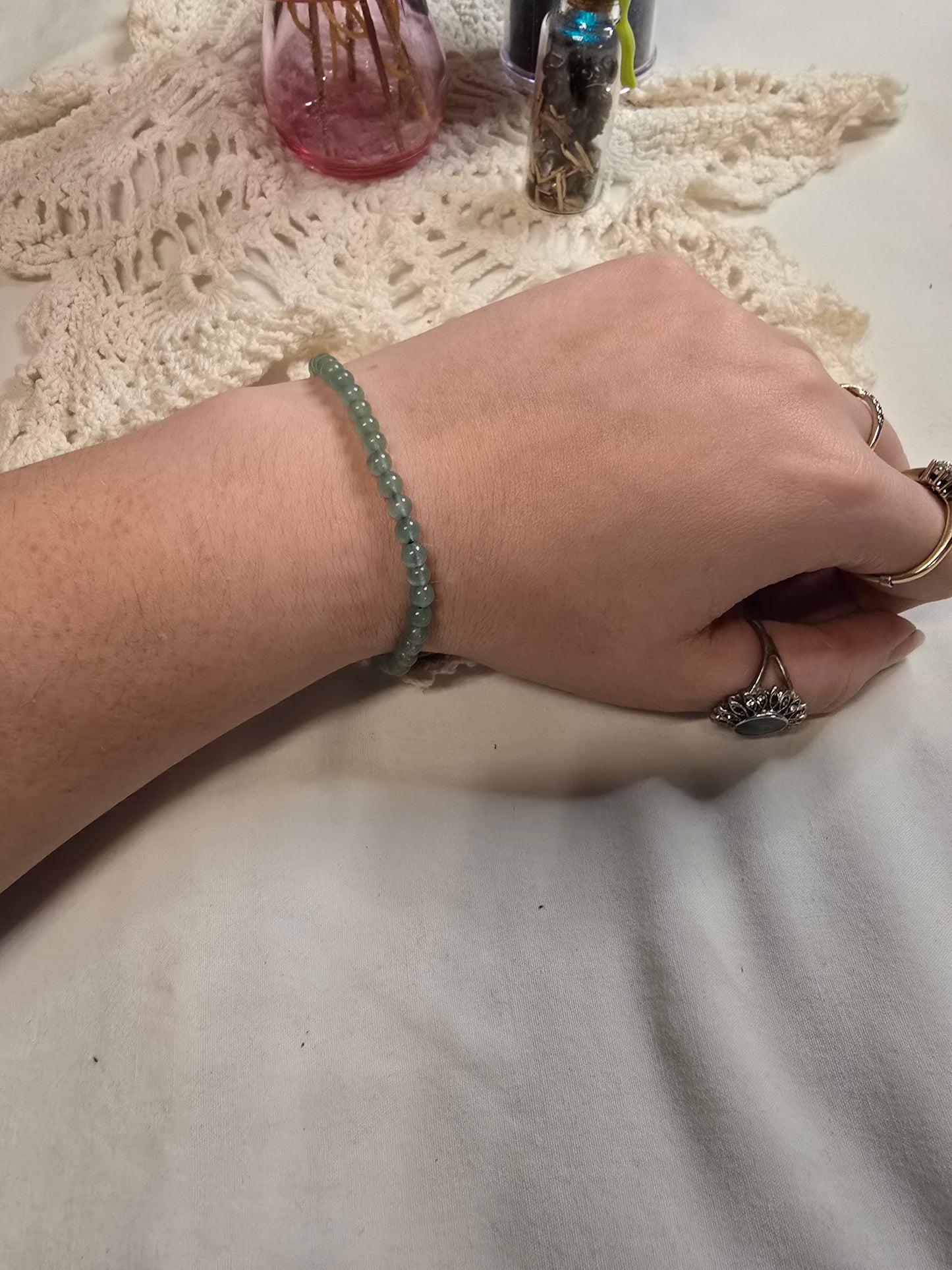 Green beaded crystal bracelet on a wrist with a white background