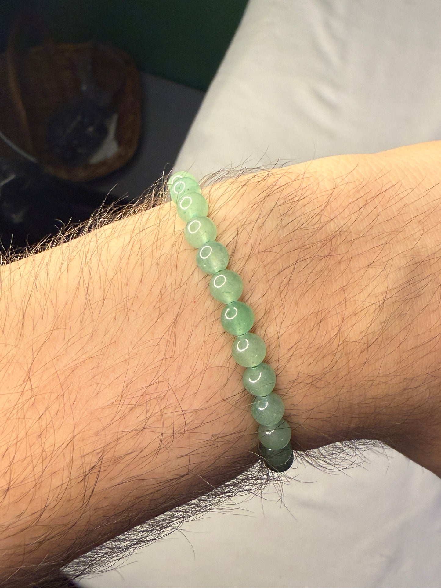 Green beaded crystal bracelet on a wrist with a blurred background