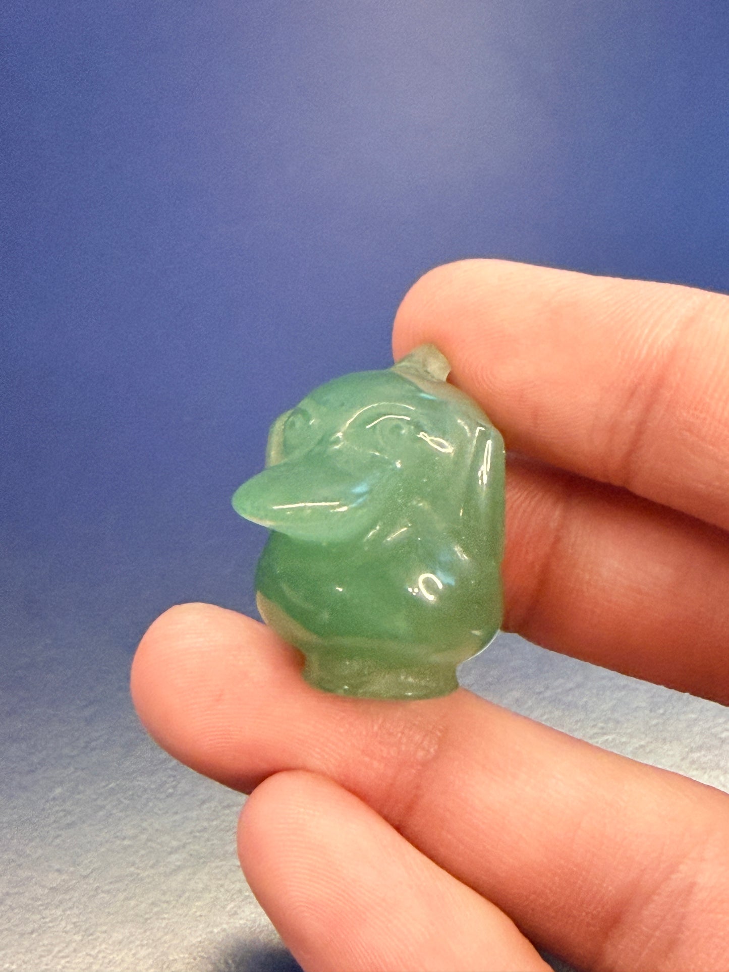 Hand holding a green Aventurine psyduck-inspired shape
