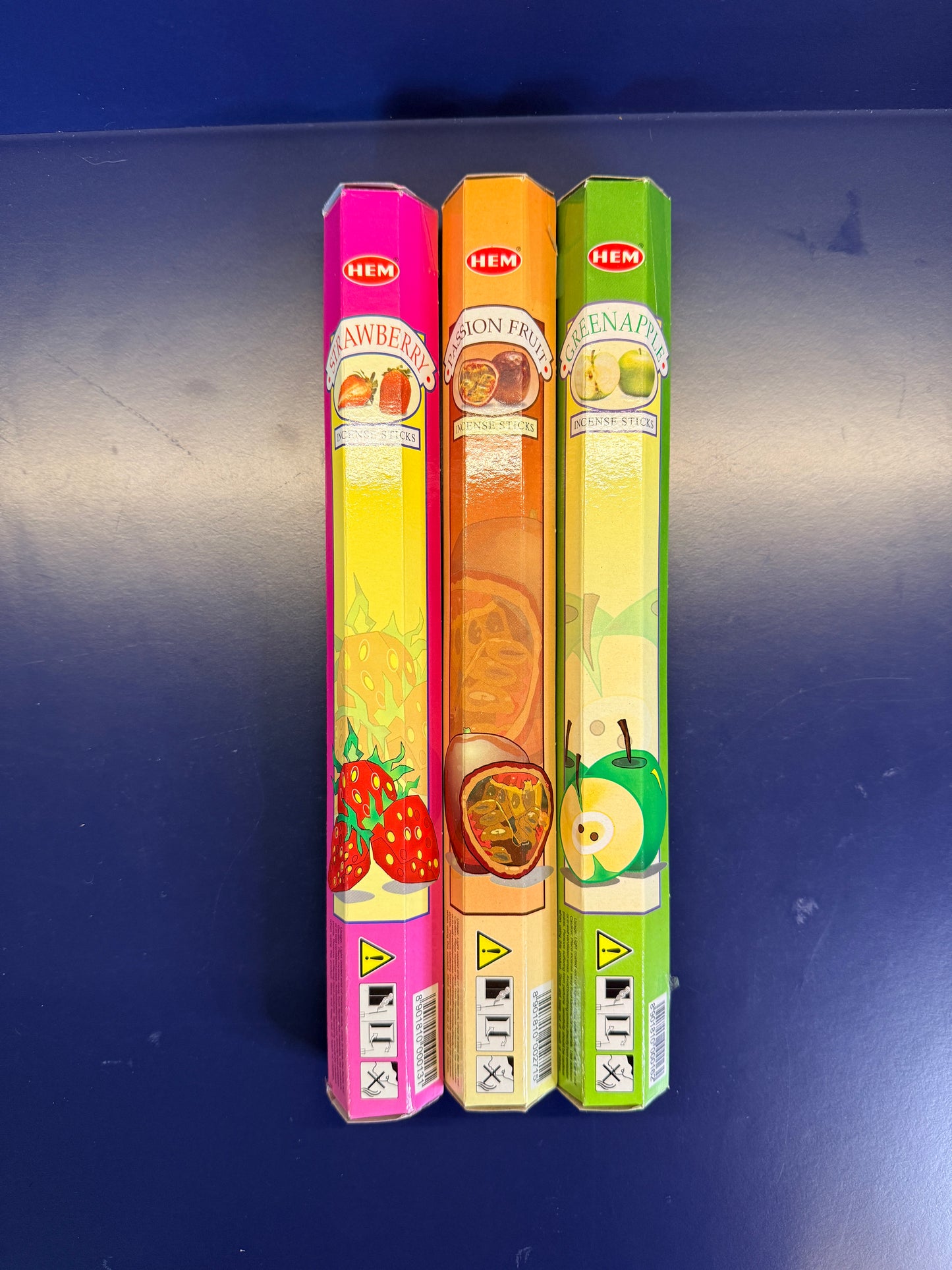 Three colorful incense boxes on a blue background