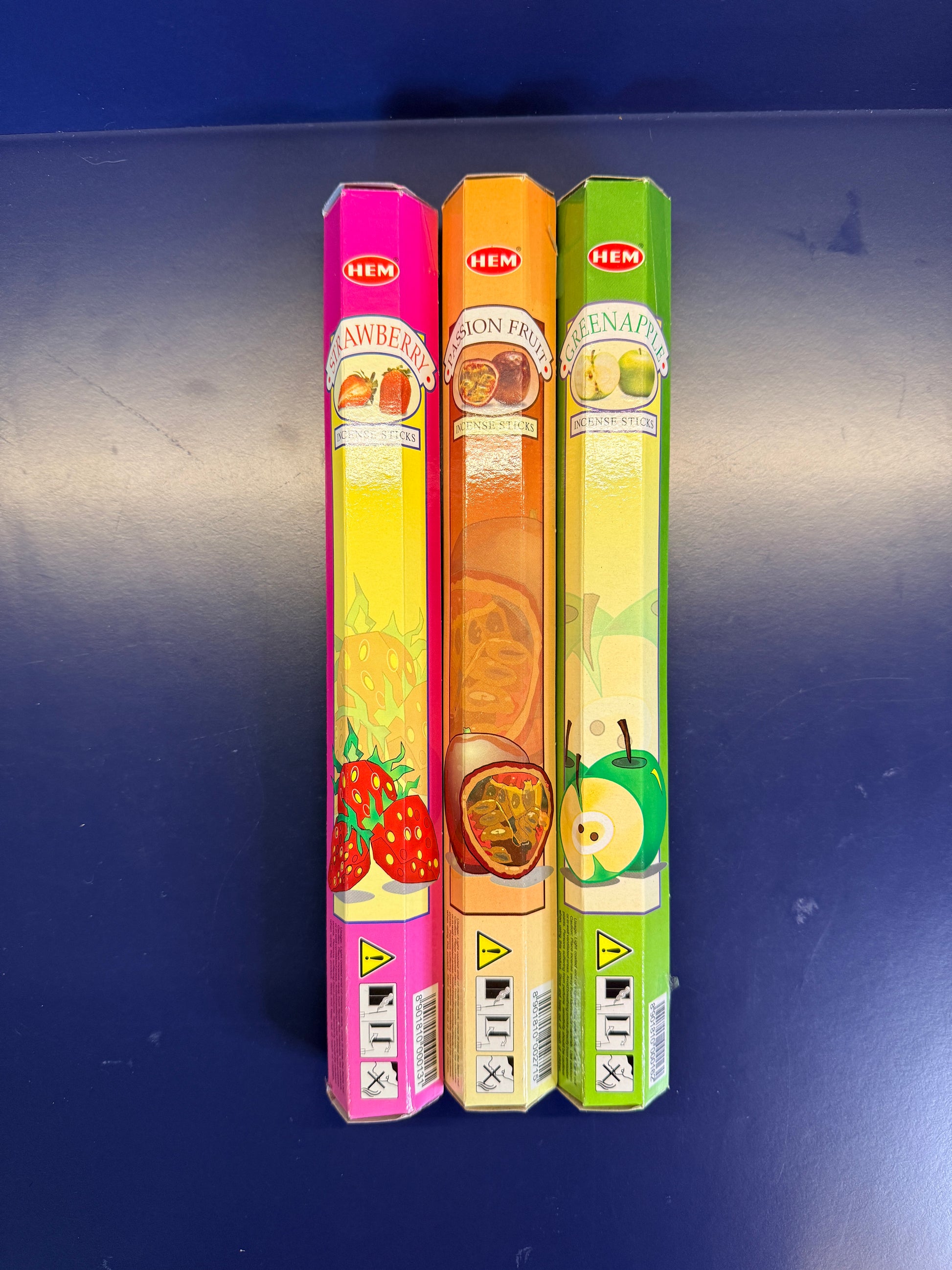 Three colorful incense boxes on a blue background