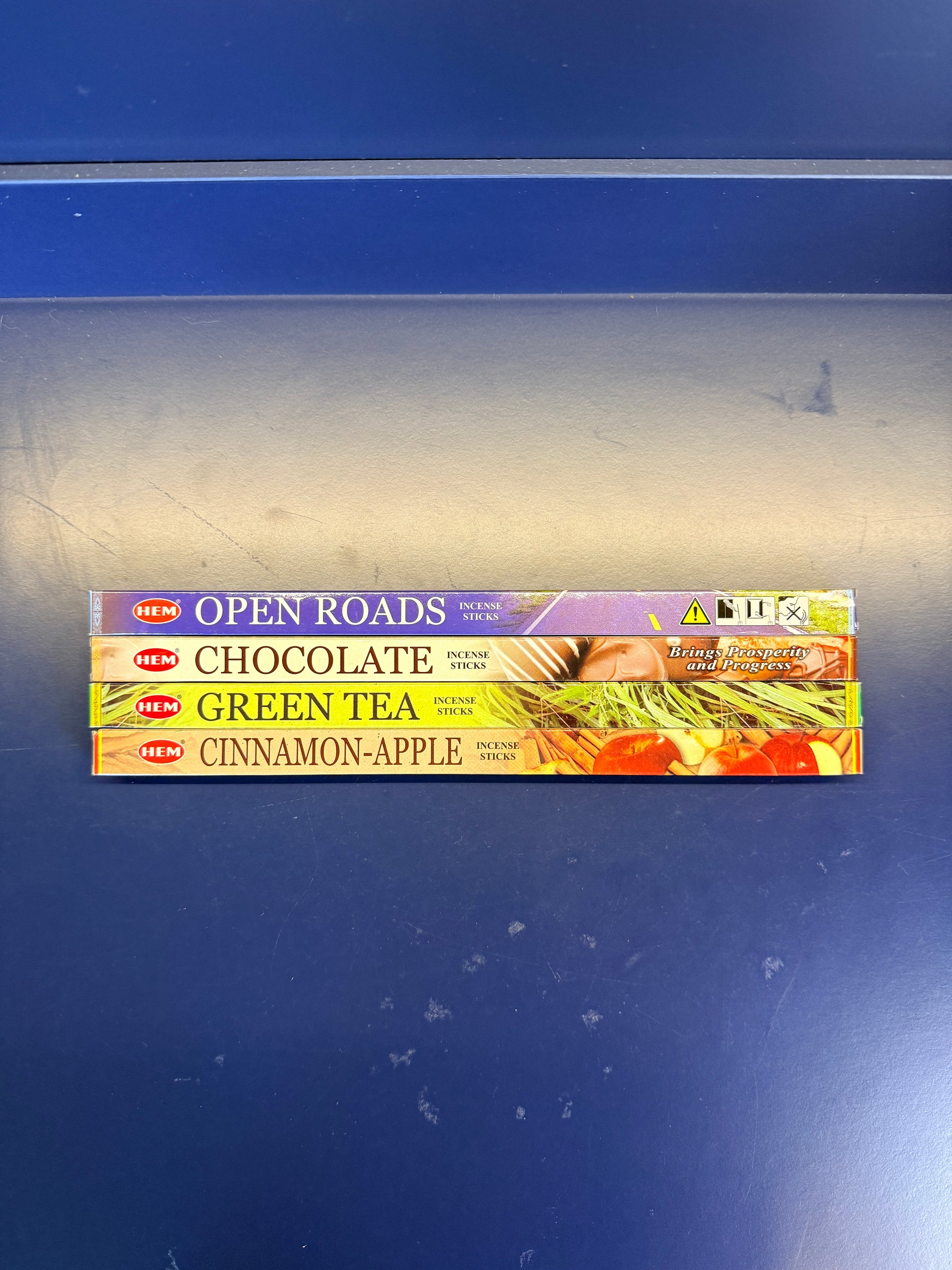 Four small colorful incense boxes on a blue background