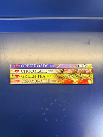 Four small colorful incense boxes on a blue background