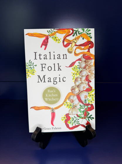 Book titled 'Italian Folk Magic' by Grace Fahrin on a stand against a dark background