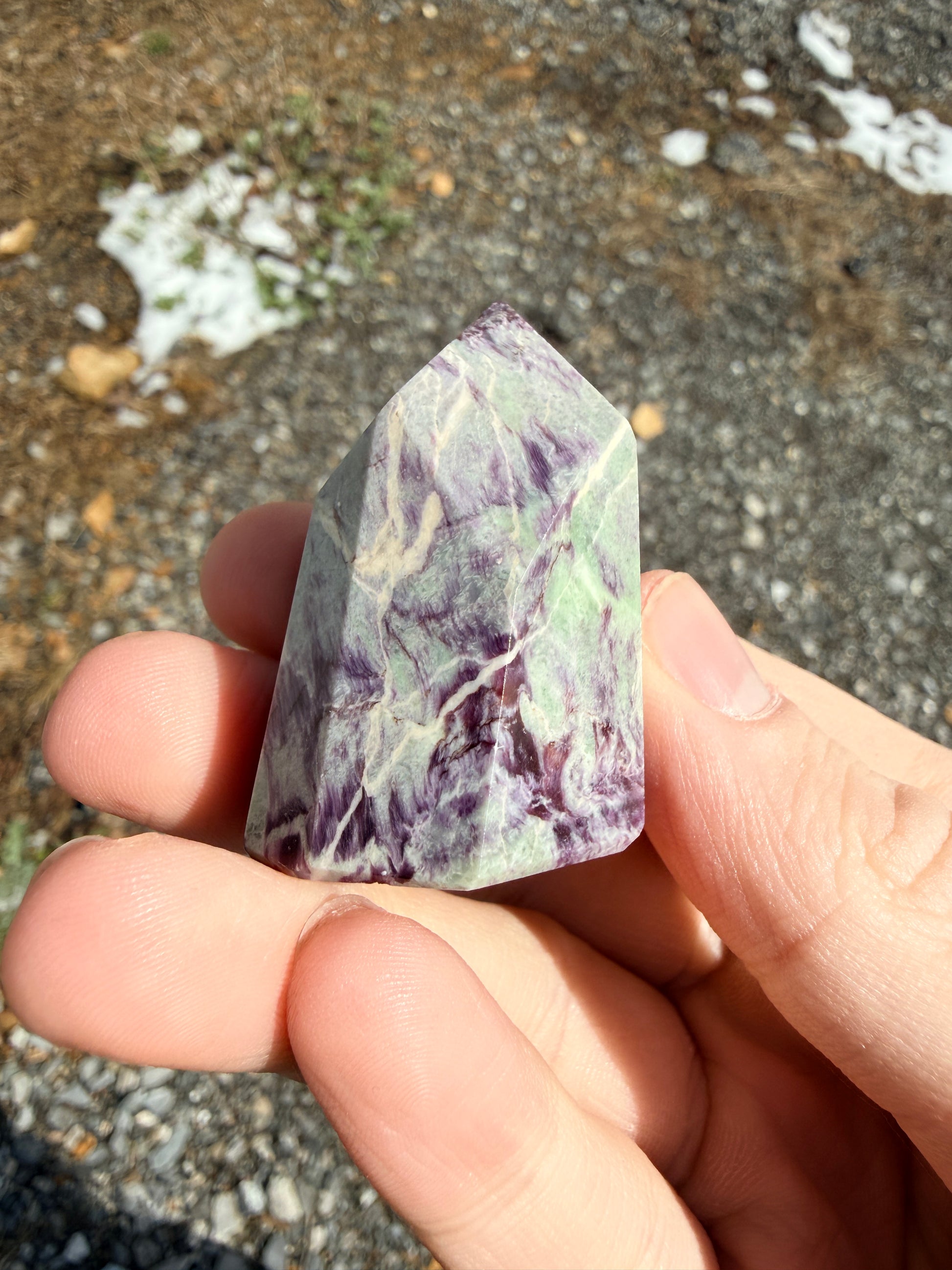 A purple and light green kammererite freeform in front of gravel