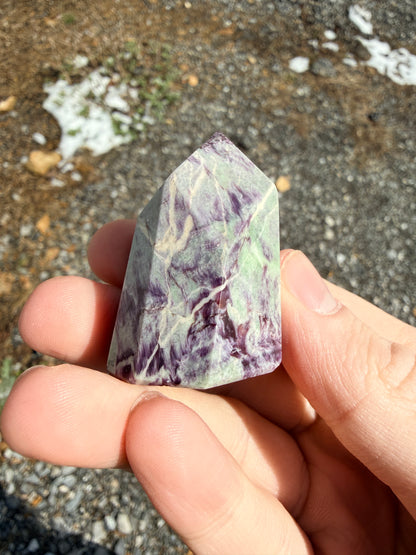 A purple and light green kammererite freeform in front of gravel