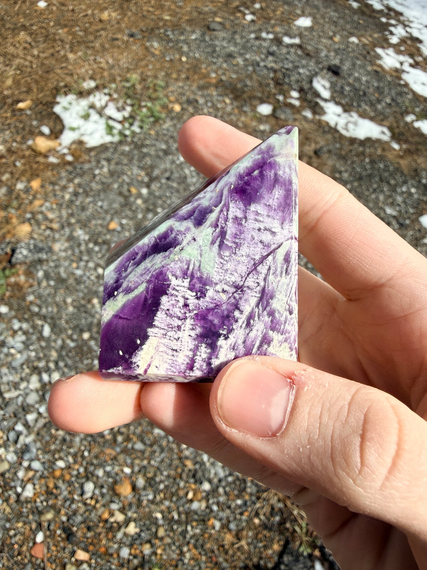 A purple and light green kammererite freeform in front of gravel
