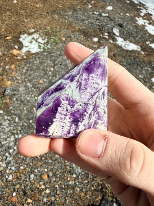 A purple and light green kammererite freeform in front of gravel