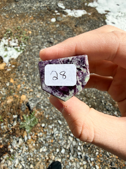 A purple and light green kammererite freeform in front of gravel