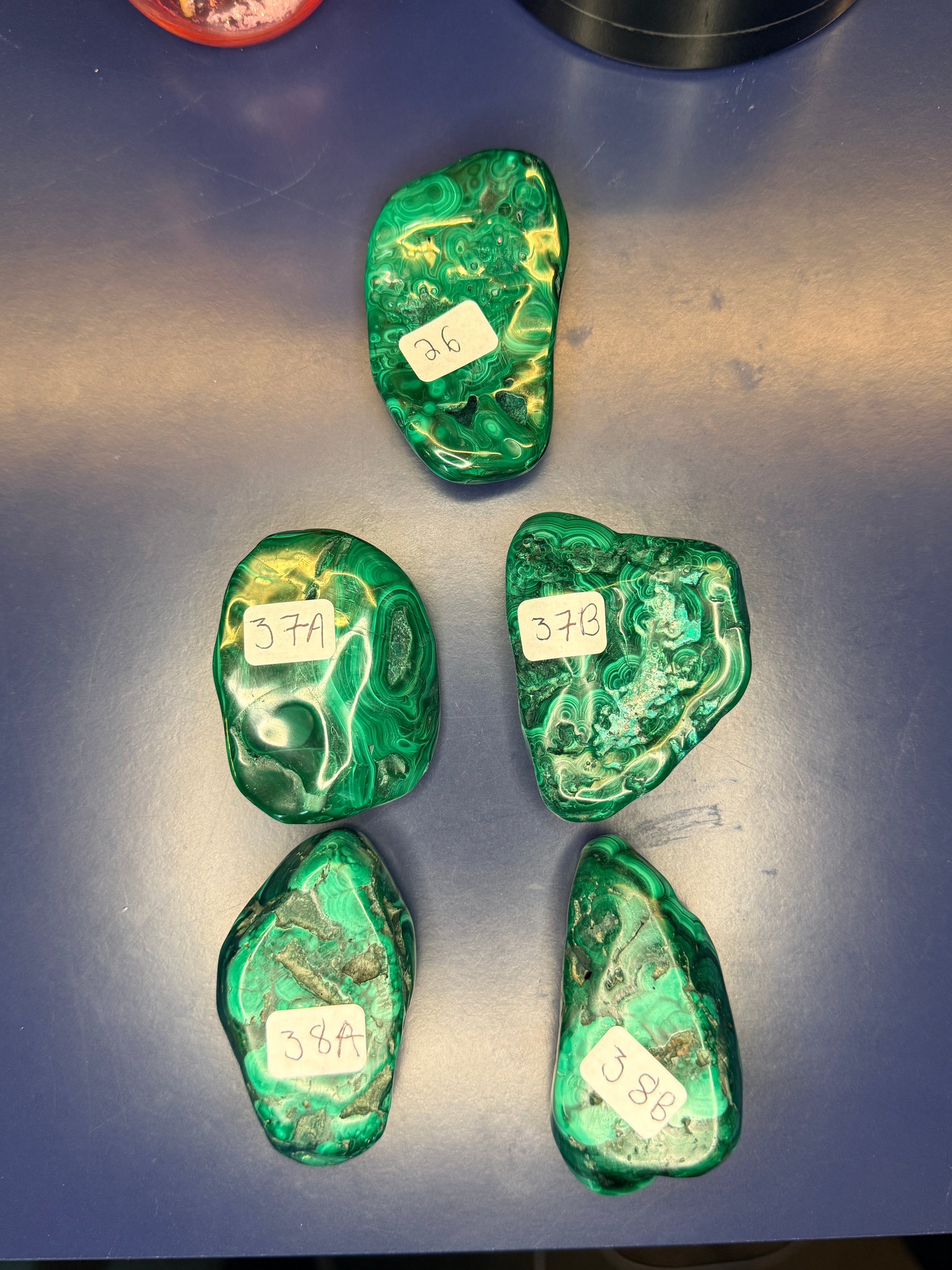 Five green marbled malachite free forms with numbered labels on a blue background
