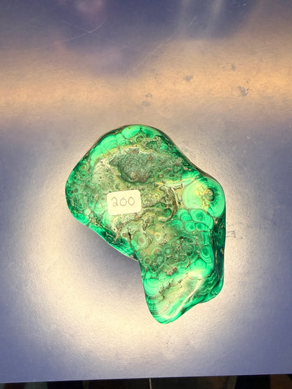 A large green marbled malachite free form with a '200' label on a blue background