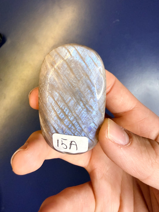 Beige and blue moonstone palmstone with the label "15A" against a blue background