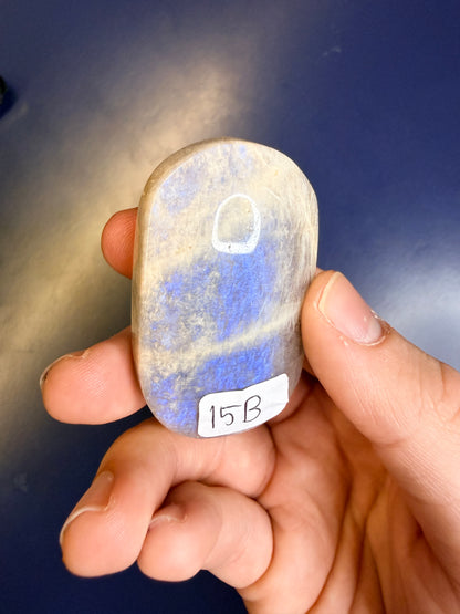 Beige and blue moonstone palmstone with the label "15B" against a blue background