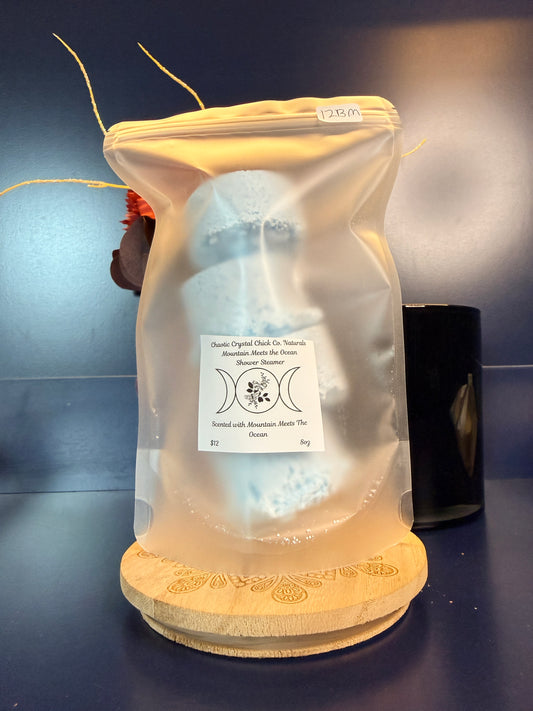 Packaged blue shower steamers on a decorative wooden coaster on a blue background