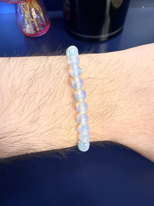 Clear Beaded crystal bracelet on a wrist with a blue background