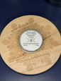 Circular labeled lip balm container on a decorative wooden coaster on a blue background