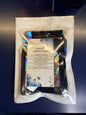 White plastic bag with a clear window showing a piece of decorative paper and smaller pouches on a blue background