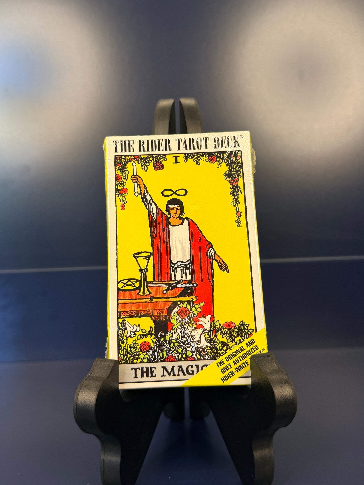 Rider Tarot Deck packaging on a black stand against a dark background