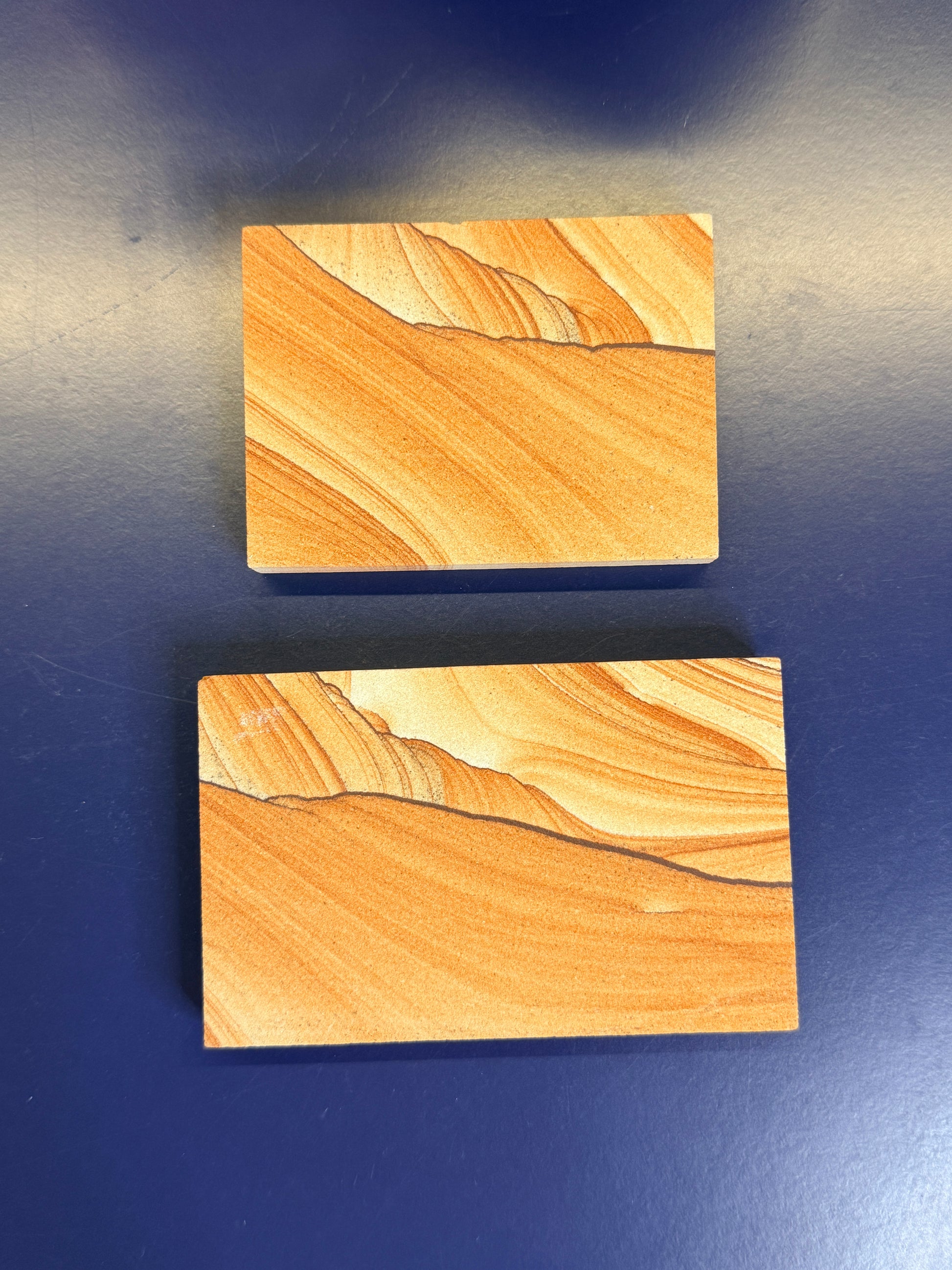 Two orange textured sandstone rectangular slabs on a blue background