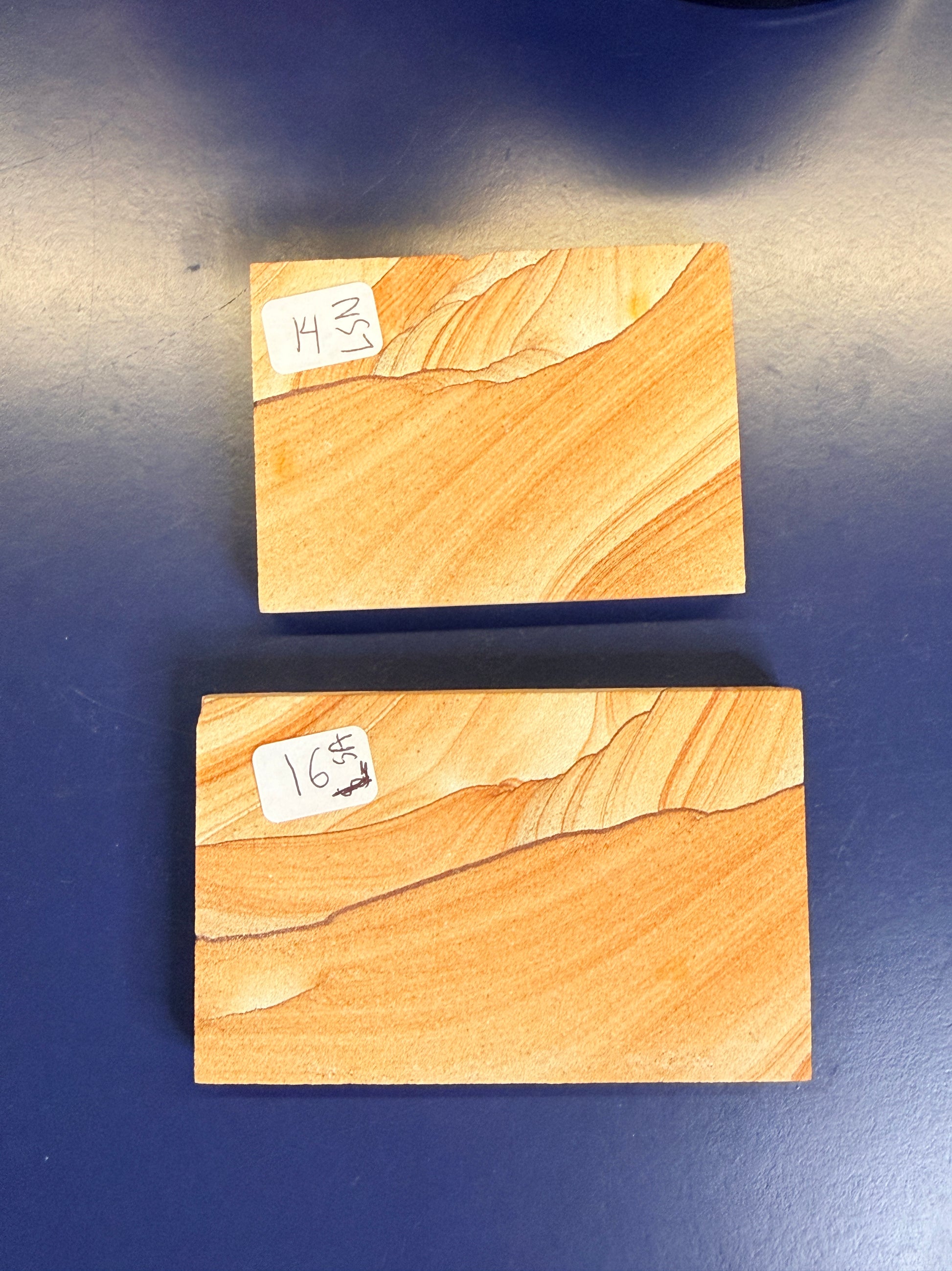 Two orange textured sandstone rectangular slabs on a blue background