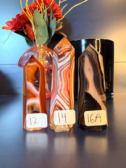 Three striped red, white, and black crystal towers in front of a mushroom and black jar