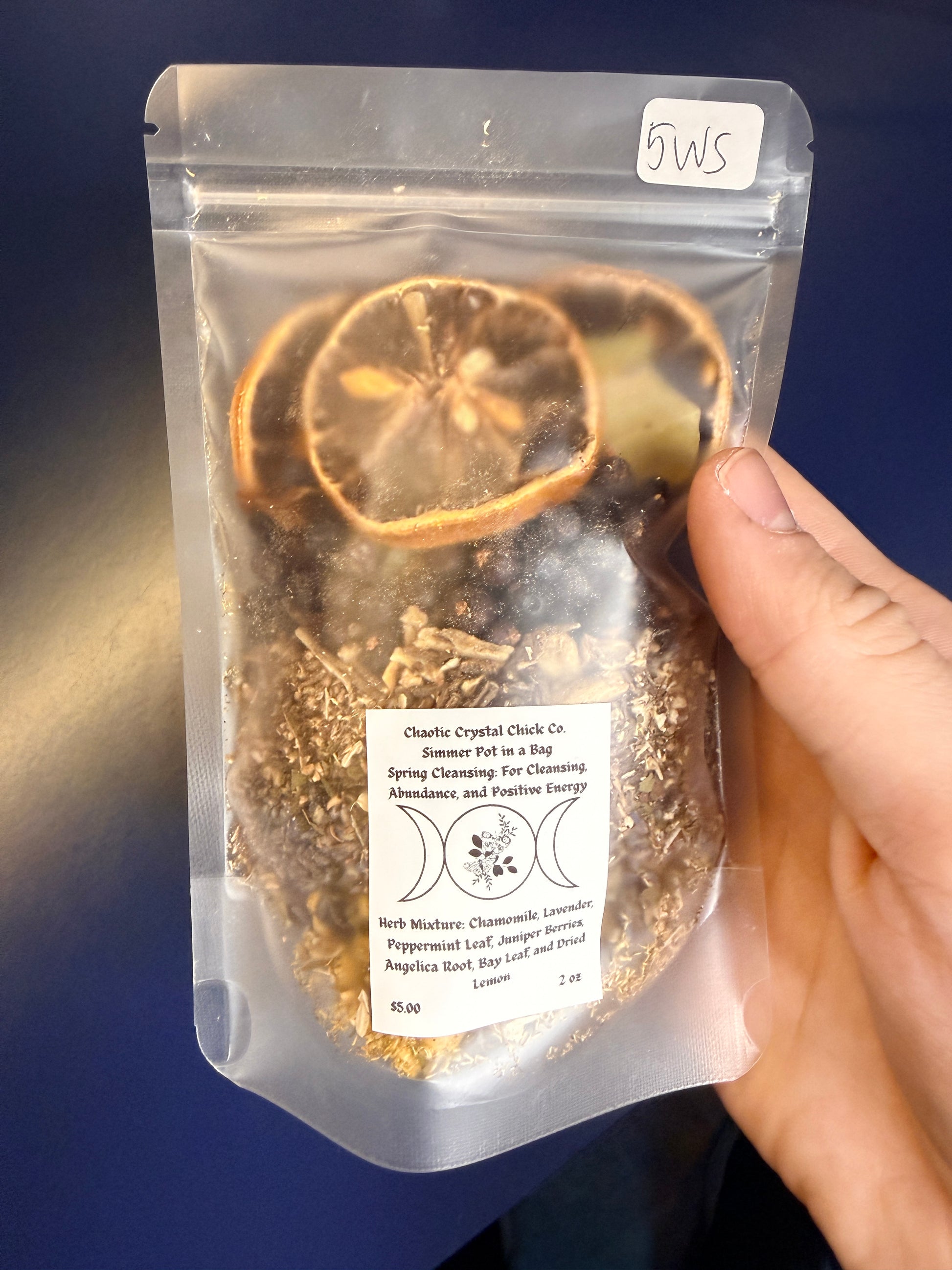 Packaged herbs on a decorative wooden coaster against a blue background