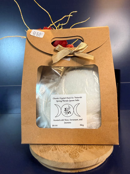 White epsom salt in a brown paper container with a bow, on a wooden coaster