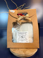 White epsom salt in a brown paper container with a bow, on a wooden coaster